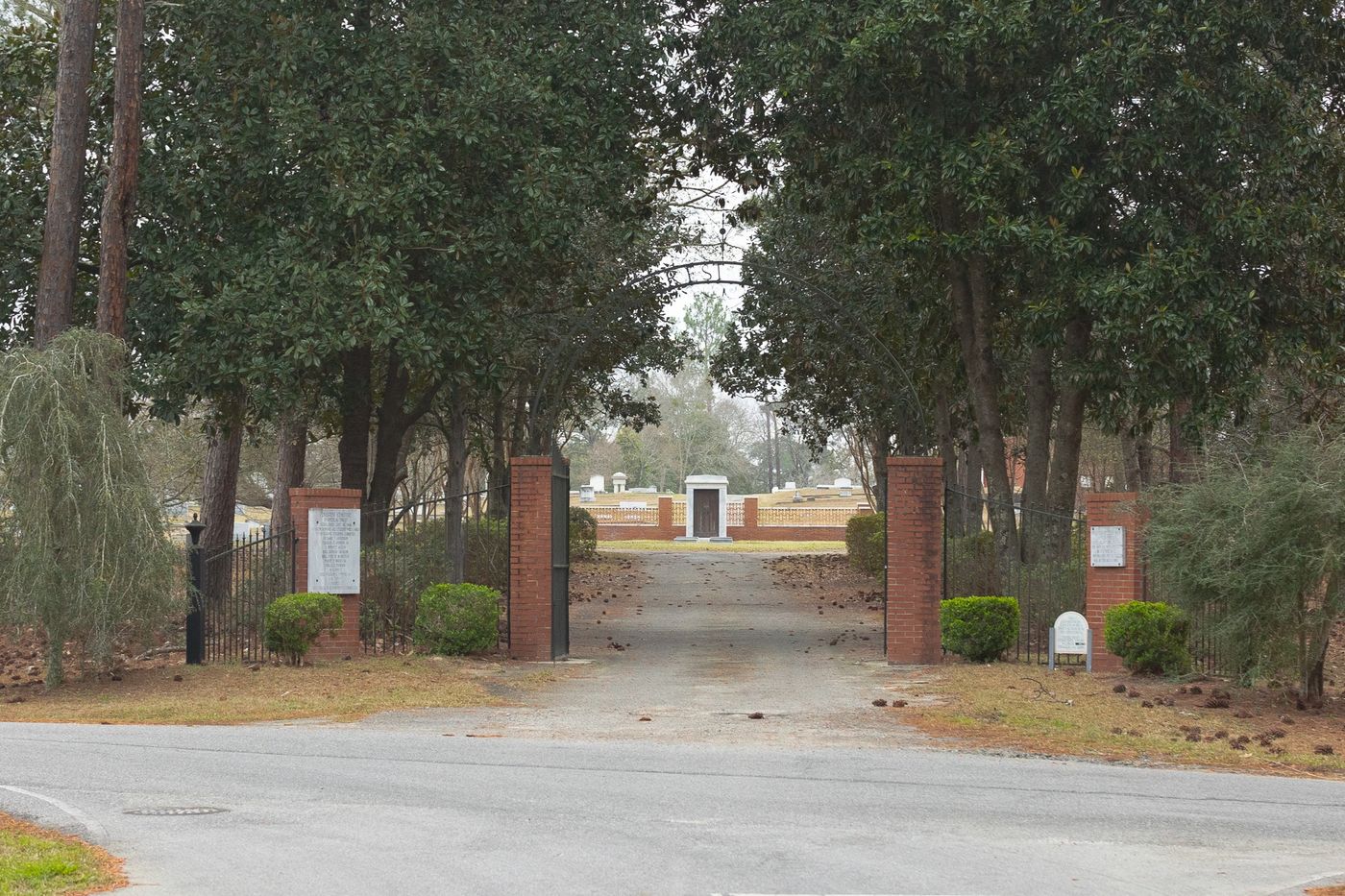 The tree-lined entrance drive and brick gate posts of Pine Crest Cemetery