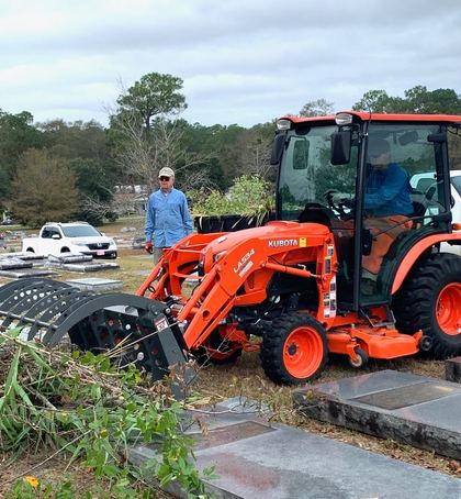 Volunteers with a tractor hauling brush